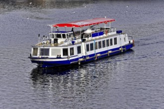 Prague, Czech Republic, Europe Passenger boat with a red roof on a calm river, Europe
