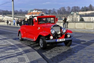 Prague, Czech Republic, Europe, Bright red vintage car on a bridge, retro atmosphere