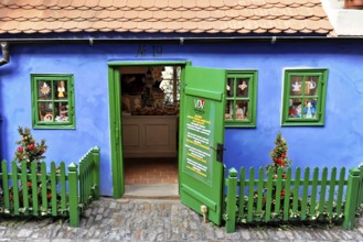 Prague, Czech Republic, Europe, Small blue house with green fence and decorative details in bright