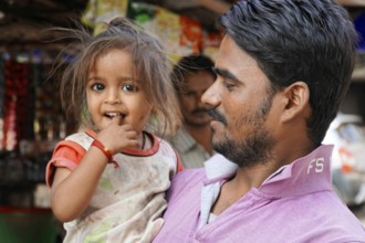 Kota, Rajasthan, North India, Asia, man carrying a little girl, both seem to have fun and smile,