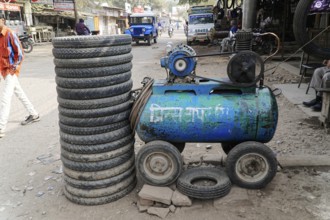 Kota, Rajasthan, North India, Asia, A pile of tyres next to a blue compressor in a dusty workshop