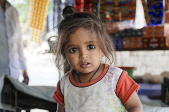 Kota, Rajasthan, North India, Asia, Little girl with a curious look in front of a colourful