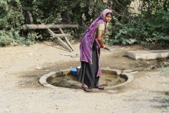 Kota, Rajasthan, North India, Asia, Woman drawing water at a traditional rural waterhole, India