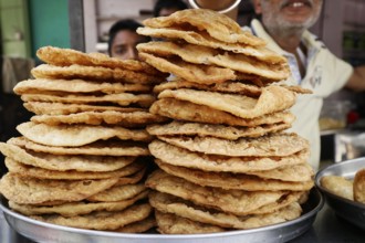 Kota, Rajasthan, North India, Asia, Stack of fried flatbreads on a market stall, India