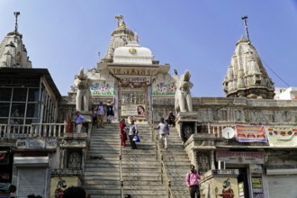 Entrance to Jagdish Temple, Udaipur, People climb the steps to a temple flanked by statues under a
