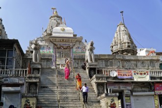Entrance to Jagdish Temple, Udaipur, People climb the steps to a temple flanked by statues under a