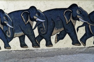 Udaipur, Rajasthan, North India, Asia, Row of painted black elephants on a light-coloured wall,