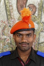 Udaipur, Rajasthan, North India, Asia, A man in uniform with an orange cap smiles in front of a