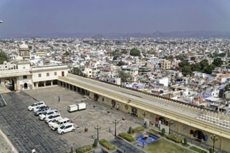 City Palace, Udaipur, Rajasthan, India, Asia, City view with a large square and parked cars in