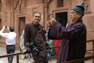 Man taking photos with smartphone in historical surroundings, Agra, Jodhpur, Rajasthan, North India
