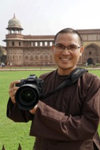 Red Fort, Agra, Uttar Pradesh, India, A smiling man with a camera stands in front of a historical