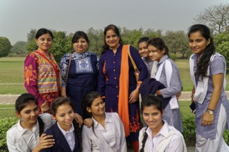 Teachers and pupils laughing together in a well-tended garden, Agra, Jodhpur, Rajasthan, North