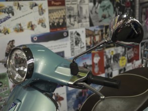 Retro scooter in blue with a chrome mirror, surrounded by billboards in the background, dortmund,