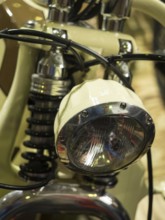 Vintage-style headlight on a cream-coloured motorbike with chrome details, dortmund, deutchland