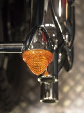 Close-up of an orange motorbike indicator with chrome frame, Dortmund, Germany