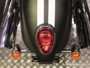 Black motorbike with red tail light and white stripes on metal floor, dortmund, deutchland