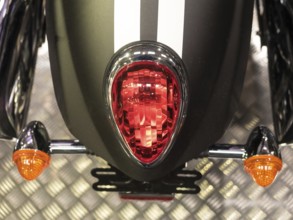 Red tail light with black stripes and orange indicators on metal base, dortmund, deutchland
