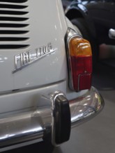 Detail of a white vintage car with tail light and bumper, gives a feeling of vintage elegance,