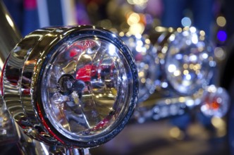Shiny chrome headlights of a motorbike, surrounded by light reflections, dortmund, germany