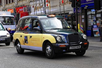 Black London taxi on a busy city street, London, London region, England, United Kingdom