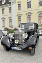 Black classic limousine-style vintage car against a historical backdrop, Retro Classics meets