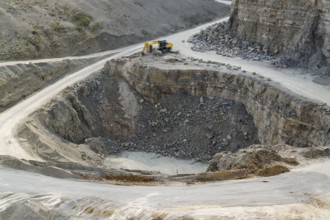 Yellow stone pit digger in stony ambiance