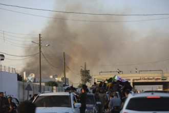 Thousands of Syrians march in Idlib carrying the Syrian revolutionary flag during a protest against