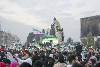 Syrians wave the revolutionary flag and gather in streets and public squares to celebrate the fall