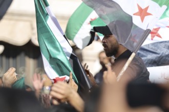Thousands of Syrians march in Idlib carrying the Syrian revolutionary flag during a protest against