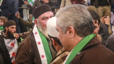 Syrians are seen demonstrating against the rule of Bashar al-Assad while carrying banners and the