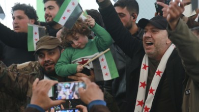 Syrians are seen demonstrating against the rule of Bashar al-Assad while carrying banners and the