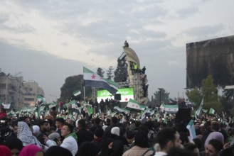 Thousands of Syrians take to public squares and main streets waving the revolutionary flag and