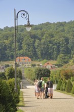 Spa gardens with tourists and pedestrians, view of Fürstenhof, street lamp, path, family excursion,