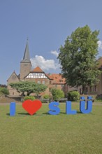 Heart sign as a symbol of solidarity and love for the city of SLÜ, monastery, church tower,