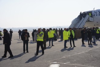 Passengers celebrate with Syrian revolutionary flags as the first flight lands at Aleppo