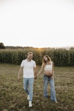 Pregnant young woman walks with her partner