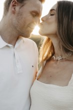 Young couple in love kissing in front of the sunset