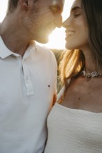 Young couple in love, nose to nose in front of the sunset