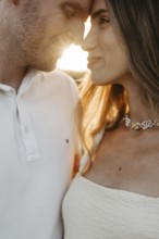 Young couple in love, forehead to forehead in front of the sunset