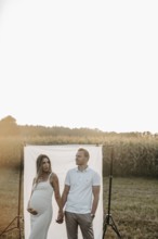 Pregnant young woman with partner at a baby bump shoot