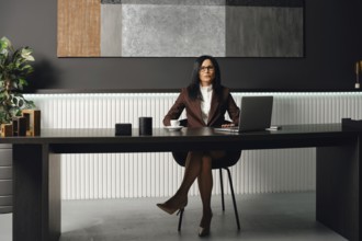 A professional lawyer dressed in formal attire sits at a sleek desk in a contemporary office