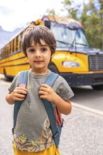 Preschool student carrying backpack and waiting for school bus, excited for first day of class,