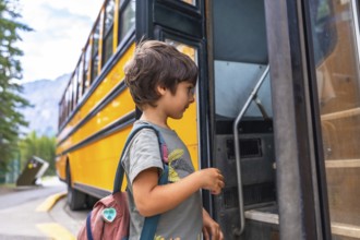 Preschool student entering a school bus, wearing a colorful backpack and beaming with excitement