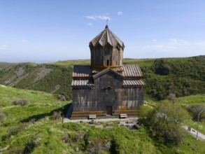 Church in front of a mountain backdrop under a bright blue sky, aerial view, Church of the Mother