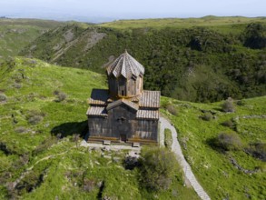 Small church in the middle of green mountains on a remote meadow, aerial view, Church of the Mother