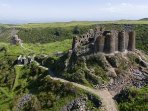 Historic castle ruins on green hills surrounded by nature, aerial view, Amberd Fortress and Mother