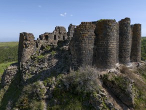 Massive ruins of a stone tower on a hill in nature, aerial view, Amberd Fortress, Aragazotn