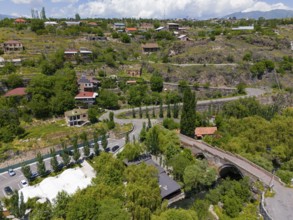Panorama of a village in a hilly landscape with roads and green vegetation, aerial view, Three-arch
