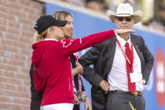 Tiffany Foster, Amy Millar and Chef d'Equipe, Ian Millar from Team Canada watch Susan Horn compete