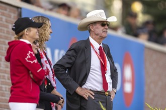 Tiffany Foster, Amy Millar and Chef d'Equipe, Ian Millar from Team Canada watch Susan Horn compete